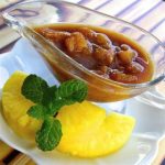 Ananas-Soja-Sauce in einer Glas-Soßenschale mit frischen Ananasscheiben und Minzblatt, fruchtige Delikatesse.